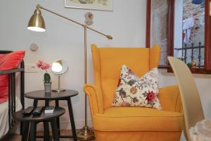 a living room with a yellow chair and a lamp at Studio Hedera in Rovinj