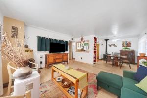 a living room with a couch and a tv at Famed Plaza Oasis 1 mile away, King Bed, Office, Foosball in Santa Fe