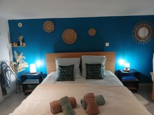 a bedroom with a large bed with blue walls at Le Cosy Cabarieu in Saint-André-de-Cubzac