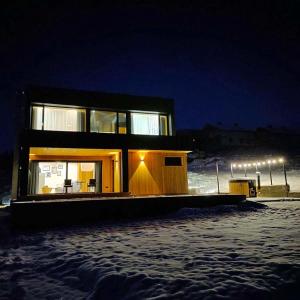 a small house in the snow at night at Котедж Загора in Novyy Kropivnik +30 photos
