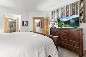 een slaapkamer met een groot bed en een flatscreen-tv bij Deer Valley Luxury Condo, Comstock Lodge, 2 Bedroom - Walk to Lifts, Private Hot Tub, Amazing Views in Park City