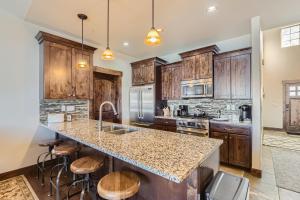 a kitchen with wooden cabinets and a large island with bar stools at Private Hot Tub, Close to Resorts - Private Hot Tub - Close to PC, Mountain Mansion Family Getaway in Park City