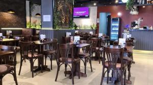 a restaurant with wooden tables and chairs in a room at Flat Residence Campinas in Campinas