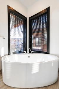 a white bath tub in a bathroom with two windows at Juniper Landing - Luxury Townhouse - Outdoor Pool, Gym, Hot Tub in Canyons Village in Park City +22 photos