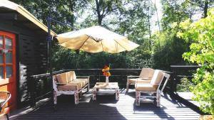a patio with chairs and an umbrella on a deck at Estero El Claro Hotel y Cabañas in Pucón