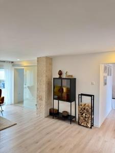a living room with a black shelf with fire wood at Modern apartment in Albstadt
