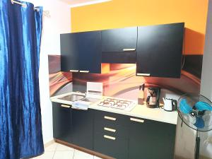 - une cuisine avec des placards noirs, un évier et une cuisinière dans l'établissement Relaxed Home to calm, à Santa Maria