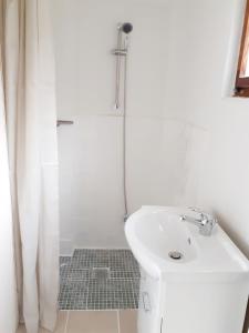 a white bathroom with a sink and a shower at Talblick 1 - Ihr Ferienhaus mitten im idyllischen Tal in Bad Bibra