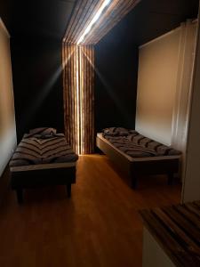 two beds in a dark room with a beam of light at Villa Northern Lights in Rovaniemi