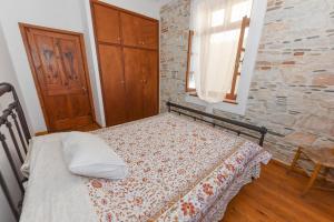 a bedroom with a bed and a stone wall at Rustic Stone House in Ágios Konstantínos