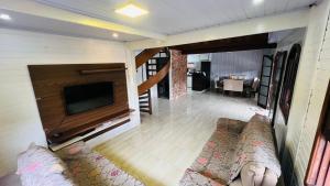 a living room with a couch and a flat screen tv at Recanto da Natureza in Matinhos