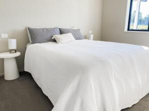 a bedroom with a white bed with a white comforter at Country Cottage in Sefton