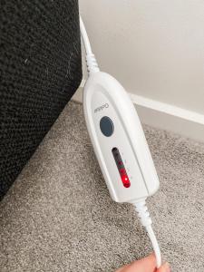 a person is holding a white electronic device at Country Cottage in Sefton