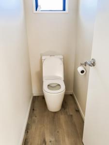 a small bathroom with a toilet with a window at Country Cottage in Sefton +19 photos