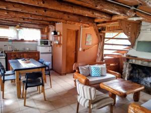 a kitchen and living room with a table and a fireplace at Alma de Puelo in Lago Puelo