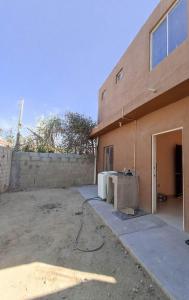 ein Gebäude mit einem Tisch vor einem Gebäude in der Unterkunft Casa texcoco in Cabo San Lucas