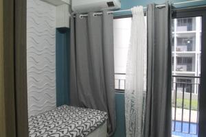 a bedroom with a bed and curtains and a window at Shore 2 Residence Tower 2 in Manila