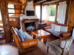 a living room with wooden furniture and a fireplace at Alma de Puelo in Lago Puelo