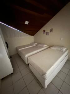2 camas blancas en una habitación con techo en Flat monte castelo condomínio, en Bezerros 15 fotos más