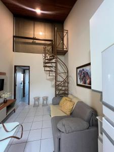 sala de estar con sofá y escalera de caracol en Flat monte castelo condomínio, en Bezerros