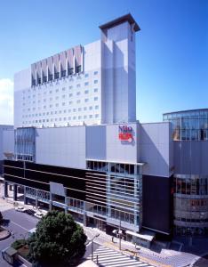 a large white building with a sign on it at Keisei Hotel Miramare in Chiba