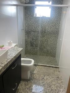 a bathroom with a shower with a toilet and a sink at Casa pé na areia in Vila Velha +21 photos