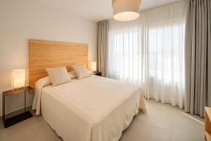 アレシーフェにあるGeria - Panasco Suitesの白いベッドと大きな窓のある寝室