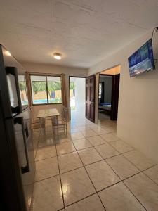 a living room with a table and a tiled floor at Koba Apartments Santa Teresa in Santa Teresa Beach
