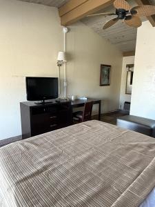 a hotel room with a bed and a flat screen tv at Cinderella Motel in Hollister
