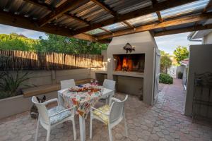 莫塞尔湾The Barefoot Cottage的带桌椅和壁炉的露台