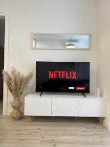 a tv sitting on top of a white entertainment center at Apartment Oasis in Orešje