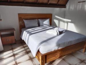 a bed with two white swans sitting on it at Nan Bungalows Tetebatu in Tetebatu