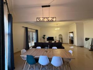Una sala de estar con una mesa y sillas de madera. en Appartement électrifié H24, en Bamako