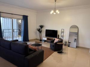 Una sala de estar con un sofá y un televisor. en Appartement électrifié H24, en Bamako