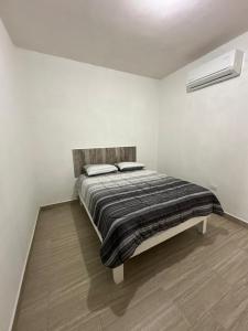 a bedroom with a bed in a white room at Apartamentos la medero 4 in Nuevo Laredo