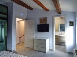 ein Schlafzimmer mit einem Bett und einem Fernseher an der Wand in der Unterkunft Casa LaSer in Cotignola + 11 Fotos