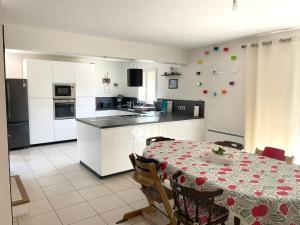 ヴェール・ポン・デュ・ガルにあるCharmante maison à 5 minutes du Pont du Gardのテーブル付きのキッチンと白いキャビネット付きのキッチン