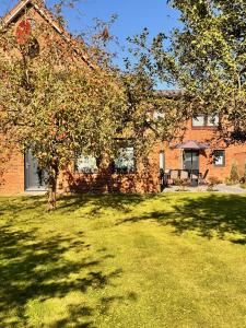 a brick house with a tree in the yard at Ferienwohnung Familie Renner in Cappel-Neufeld