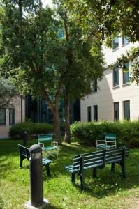 a group of benches in the grass in front of a building at L'incanto Di Boccadarno in Marina di Pisa