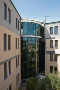 an external view of a glass building between two buildings at L'incanto Di Boccadarno in Marina di Pisa