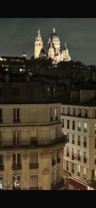 a view of a building with a city in the background at Studio avec vue sur Sacré-Coeur in Paris +5 photos