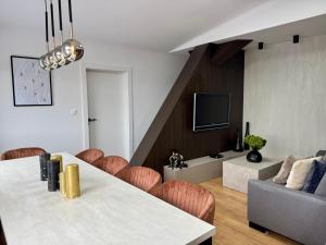 a living room with a table and chairs and a tv at Apartmány Mammut a Yetti-Šafran Donovaly in Donovaly
