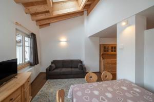 a living room with a bed and a couch at Casa Chatrian in Moena