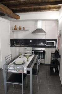a kitchen with a table with chairs and a microwave at Casa Amélia in Vila Nova de Foz Coa