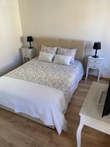 a bedroom with a bed with two tables and two lamps at Casa Amélia in Vila Nova de Foz Coa