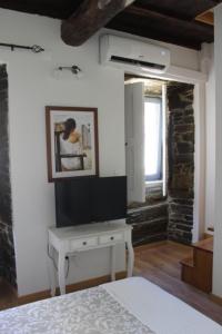 a bedroom with a bed and a desk in a room at Casa Amélia in Vila Nova de Foz Coa +10 photos