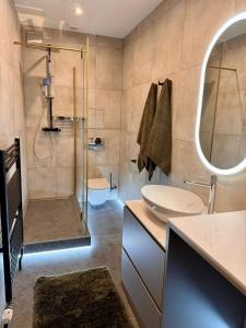 a bathroom with a shower and a sink and a mirror at Apartmány Mammut a Yetti-Šafran Donovaly in Donovaly