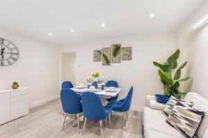 サウスエンド・オン・シーにあるModern 2 Bed Gem Southend on Sea Free parkingのダイニングルーム(テーブル、青い椅子付)