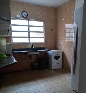 a kitchen with a sink and a stove and a window at Casa com vista para o mar! in Peruíbe