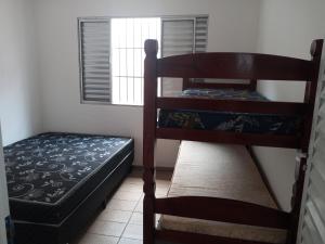 a bedroom with two bunk beds and a window at Casa com vista para o mar! in Peruíbe